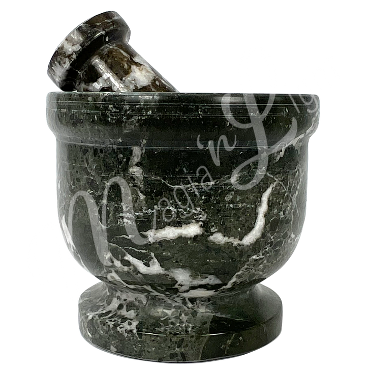 Black zebra marble with white veining mortar and pestle set. Seen from the side.